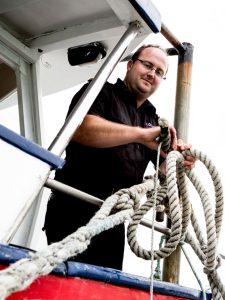 man working in a marina operations with ropes